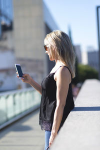 Side view of woman using mobile phone