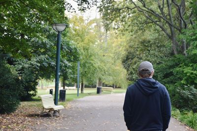 Rear view of young man wearing a cap in park during early autumn