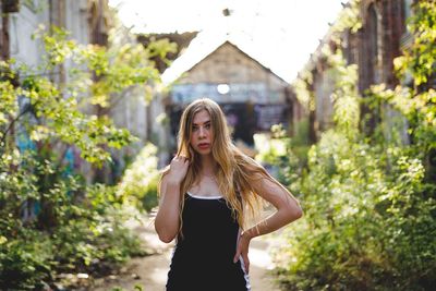 Full length of young woman standing against trees