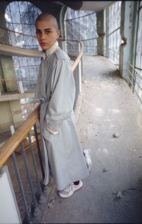 Portrait of young man standing on staircase