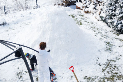 Rear view of woman standing on snow