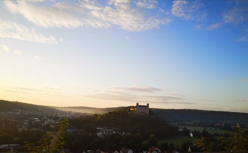 Buildings in town against sky during sunset