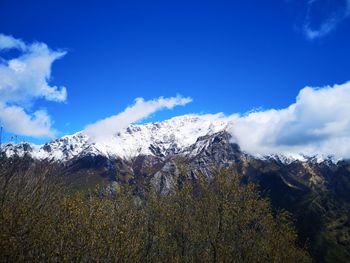 Scenic view of snowcapped mountains against blue sky