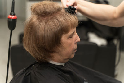 An elderly woman in a beauty salon does her hair