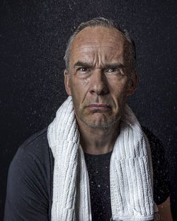 Portrait of young man against black background