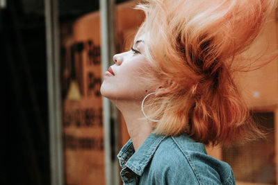 Profile view of woman with tousled hairs outdoors