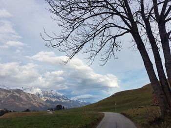 Scenic view of road by mountains against sky