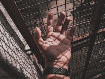 Close-up of man by metal grate 