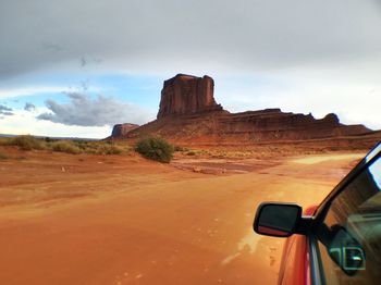 Car driving towards rock formation