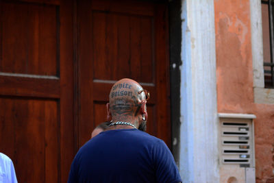 Side view of man standing against wall