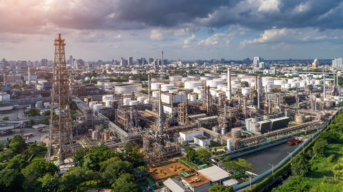 High angle view of city buildings against cloudy sky