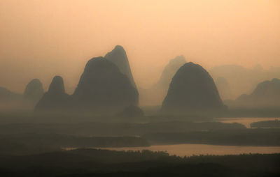 Scenic view of silhouette mountains against sky during sunset