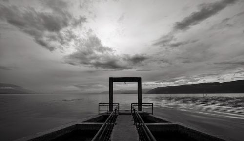 Jetty leading towards sea against sky