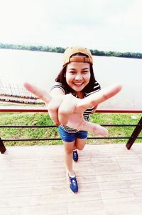 Portrait of smiling young woman against sky