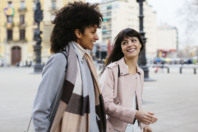 Smiling young woman standing on street in city