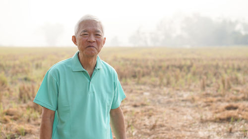 Portrait of senior man standing on field