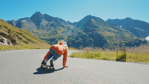 Full length of woman walking on road against mountain