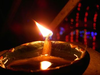 Close-up of lit candle in dark room