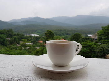 Close-up of coffee on table against mountains