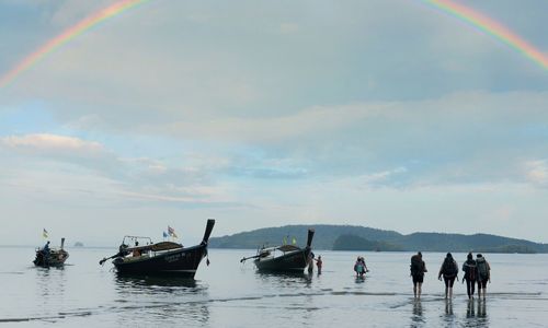 People on sea against sky