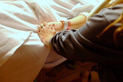 High angle view of man consoling patient lying on bed in hospital