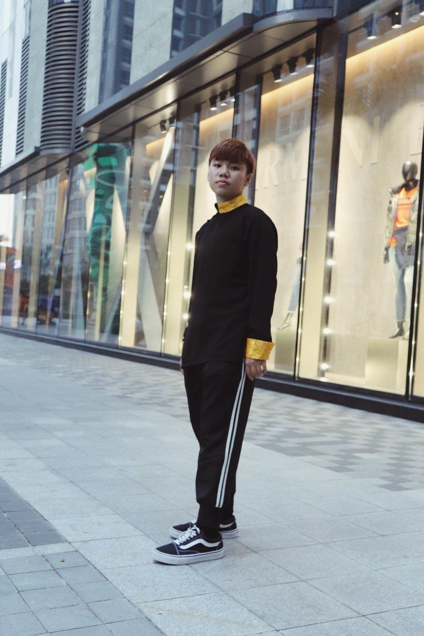 one person, full length, building exterior, architecture, built structure, real people, young adult, lifestyles, city, looking at camera, building, day, young men, glass - material, well-dressed, walking, casual clothing, portrait, outdoors, office building exterior