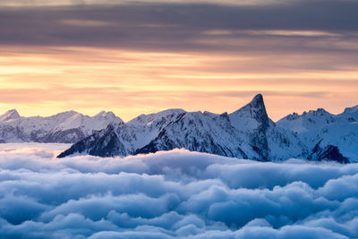 Snowcapped mountains against sky during sunset