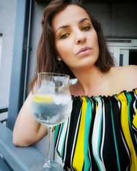 Portrait of young woman drinking glass