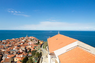 High angle view of townscape by sea against sky