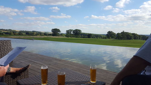 Woman relaxing in swimming pool against sky