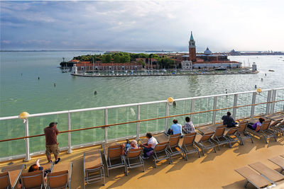 People on boat in sea against sky