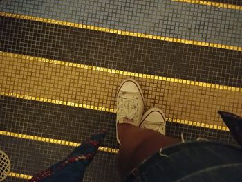 Low section of person standing on tiled floor