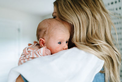 Closeup portrait of a newborn baby girl being held by her mother