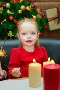 Portrait of cute girl playing with christmas tree