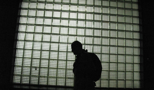 Silhouette man standing against window