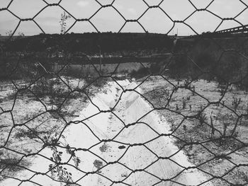 Scenic view of field seen through chainlink fence