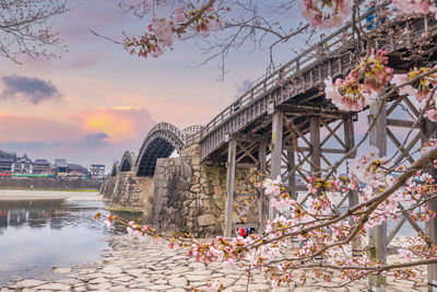 Bridge over river against sky during sunset