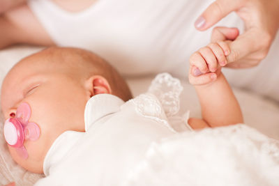 Cute baby holing mothers finger