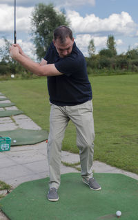 Full length of boy playing on golf course