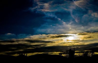 Silhouette of landscape against cloudy sky