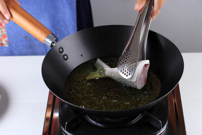 Cropped hand of man holding cooking pan