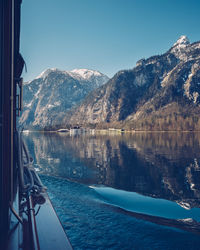 Scenic view of lake and mountains against clear blue sky