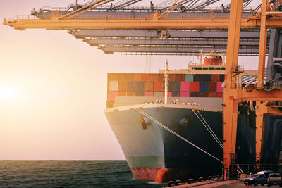 Low angle view of illuminated commercial dock by sea against sky