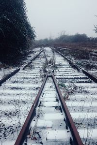 Railroad tracks against clear sky during winter