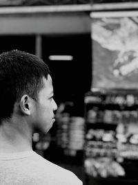 Young man looking away while standing outdoors