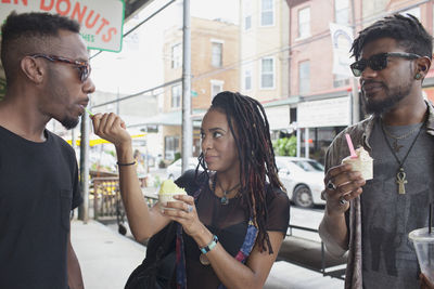 A young woman feeiding a young man frozen yoghurt.