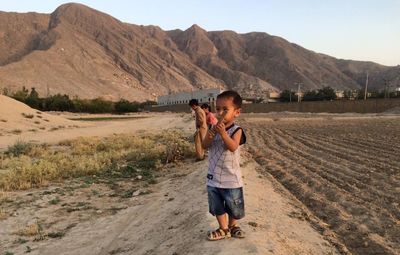 Full length of a boy standing on landscape