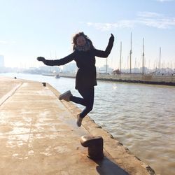 Woman jumping on harbor