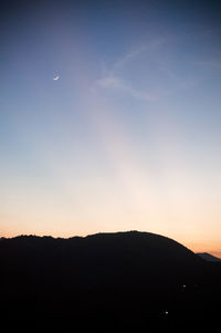 Scenic view of silhouette mountains against clear sky at night