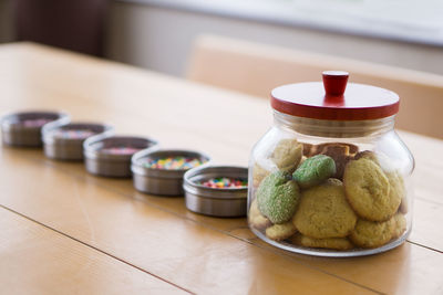 Close-up of colorful candies in bowls with cookies on table